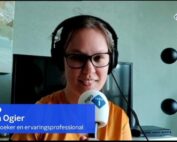 Stil uit het videobeeld van de uitzending van Nieuws & Co. Ik ben een indo vrouw met donker haar in een staartje, ik draag een bruin montuur bril, koptelefoon en okergele blouse. Voor mijn gezicht heb ik een microfoon met NPO Radio 1 erop. Links in beeld een blauwe balk van Nieuws & Co met de tekst "Jiska Ogier, onderzoeker en ervaringsprofessional".