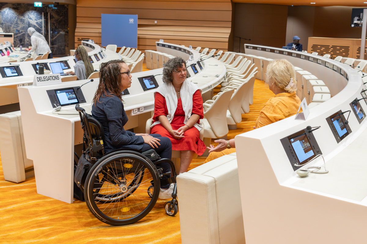 Foto door Jens Van Hecke: Illya Soffer (oud-directeur Iederin), Roos Hoelen-van Delft en ikzelf zijn met elkaar in gesprek in de zaal van het VN-comité Handicap in Genève. 